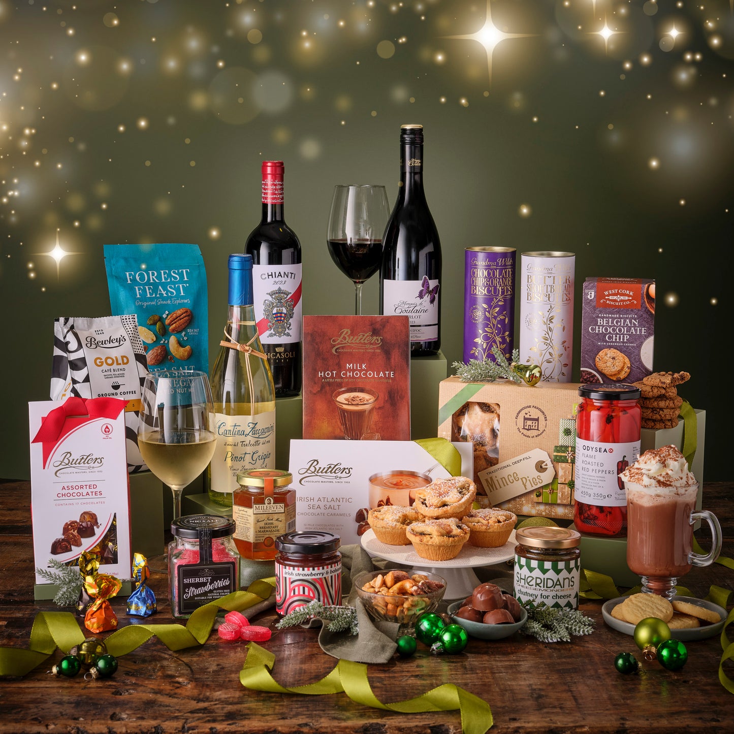 Assorted holiday food and drink items on a wooden table with a festive background.