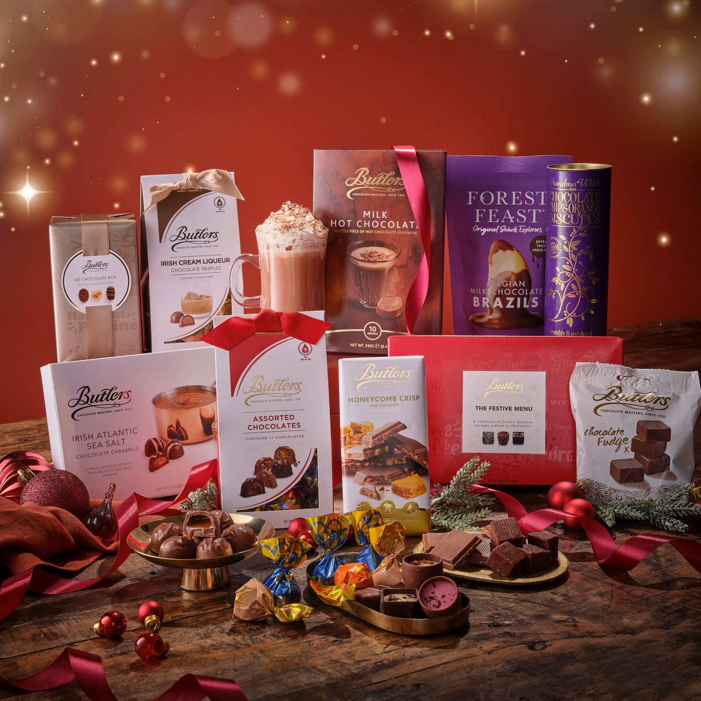 Assorted Butler's chocolate and confectionery products on a wooden table with a festive background.