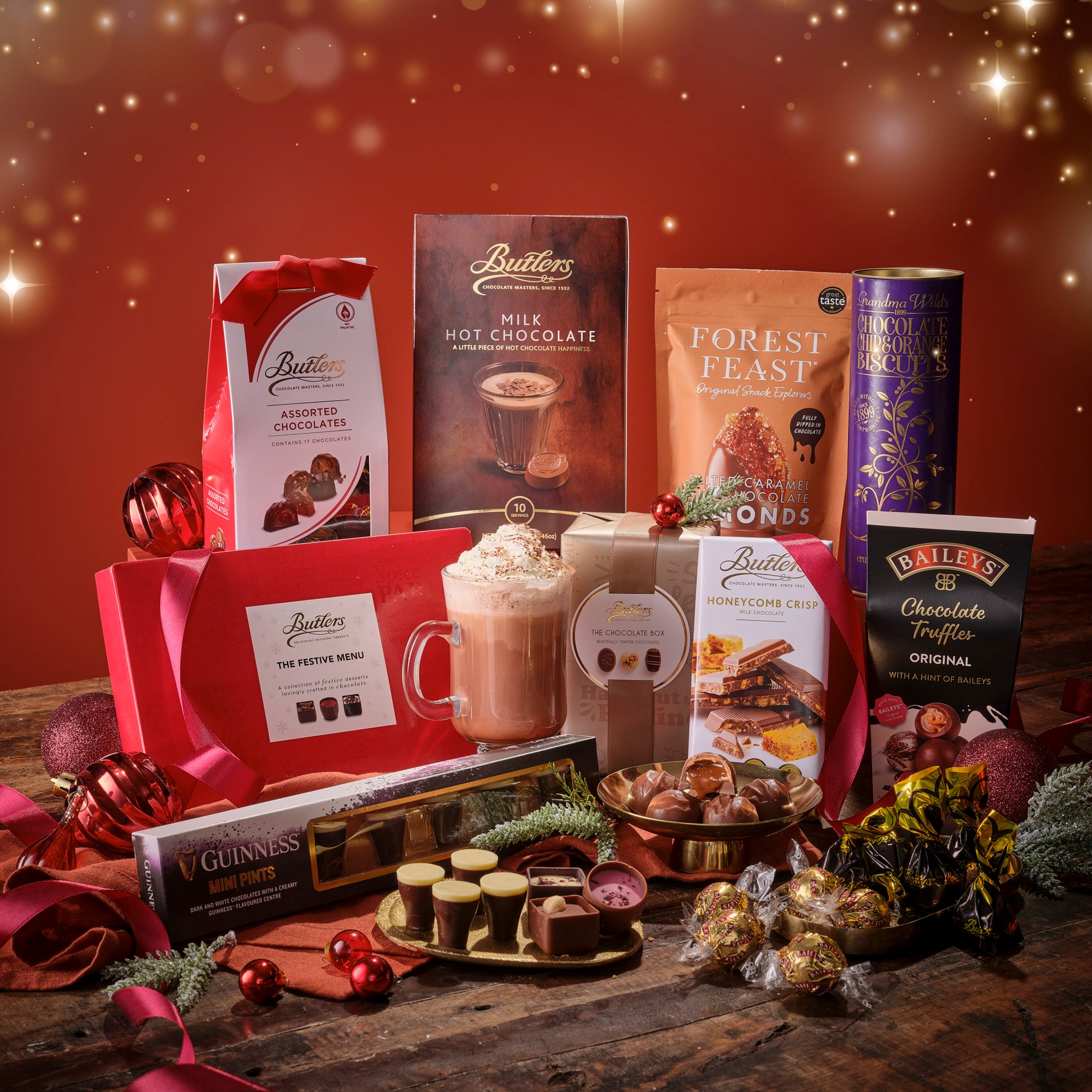 Assorted chocolate and hot chocolate products on a wooden surface with a festive background.