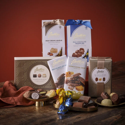 Chocolate treats hamper with Butlers chocolate boxes and assorted chocolates displayed on a wooden surface.