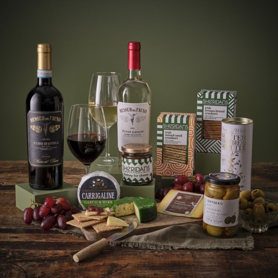 Deluxe Cheese and Wine Hamper with two wine bottles cheeses and crackers on a wooden table