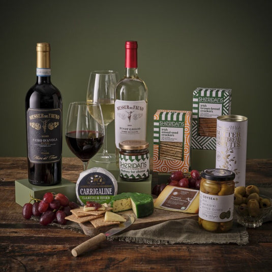 Deluxe Cheese and Wine Hamper with two wine bottles cheeses and crackers on a wooden table