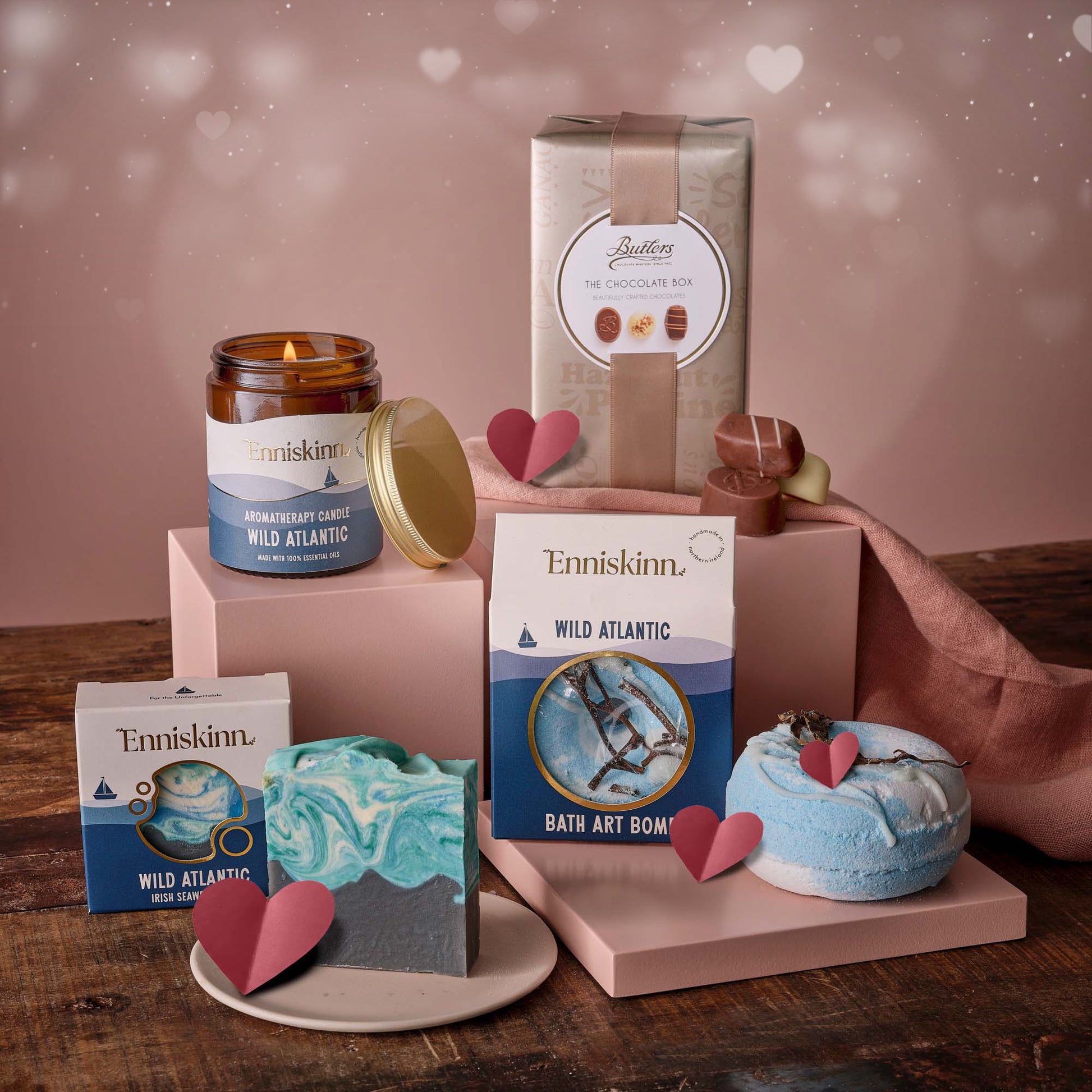 Enniskinn romantic escape gift set with scented candle bath products and blue marbled soap on a pink display.