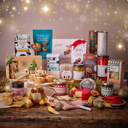 Assorted gourmet food items on a wooden table with a festive background