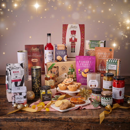 Assorted food products including jars, bottles, and boxes on a wooden table with a festive background.