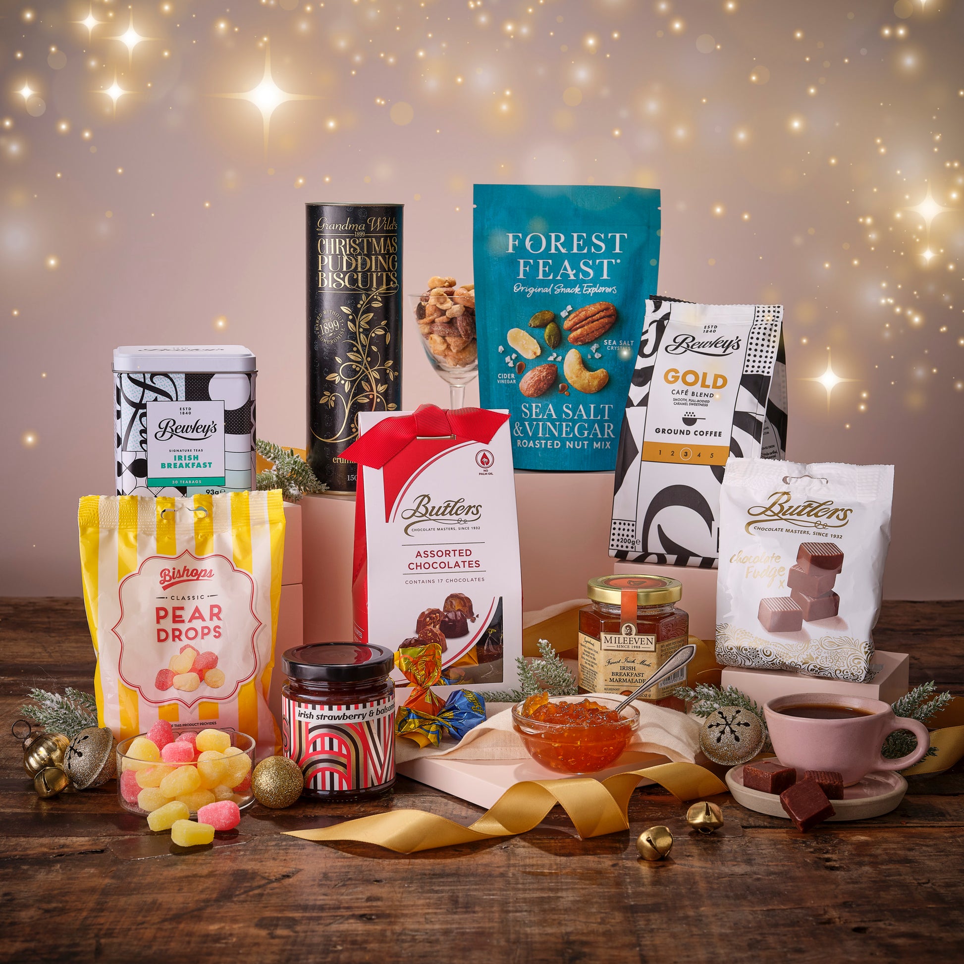 Assorted Sweets, Butlers chocolates, Bewleys Tea and decorative items on a wooden board with a festive background