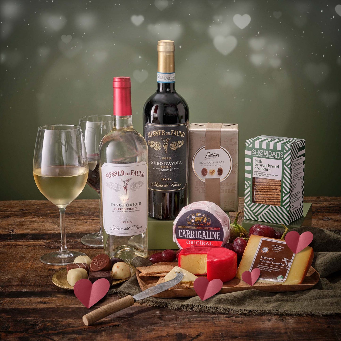 Date Night Essentials Hamper with wine cheese chocolates crackers and gourmet snacks on a wooden board.