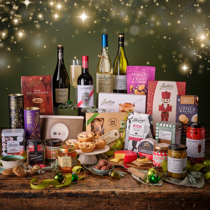 Assorted holiday products including wine, cheese, and cookies on a wooden table with a festive background.