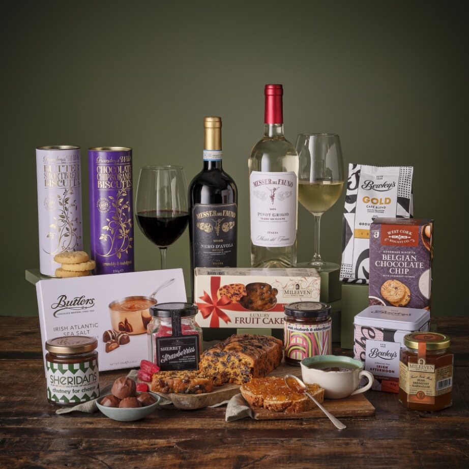 Two wine bottles with glasses and a selection of biscuits chocolates and gourmet treats for The Classic Hamper
