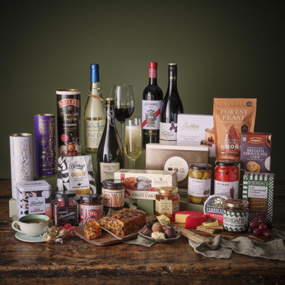 The premium gourmet hamper filled with cheeses chocolates crackers and jars on a wooden table