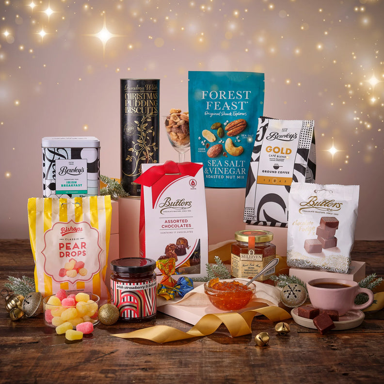 Assorted food and confectionery items on a wooden table with a festive background.