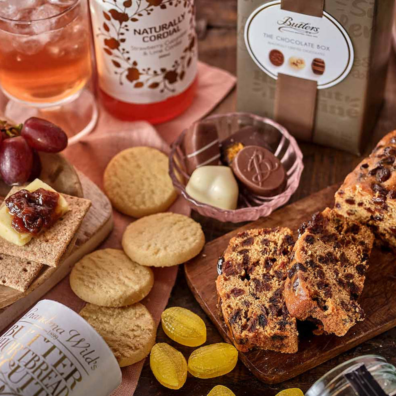 Table setting with cheese, tea and snacks on a wooden surface
