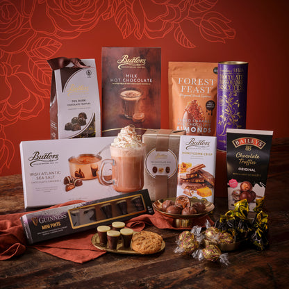 Mother’s Day Chocolate Heaven Hamper packed with chocolates cookies truffles and treats against a warm red backdrop