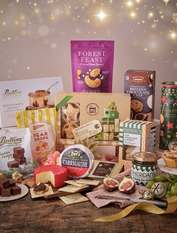 Assorted gourmet food items on a wooden table with a festive background