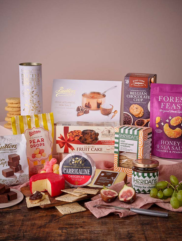 Assorted cheeses, crackers, spreads and treats on a wooden board