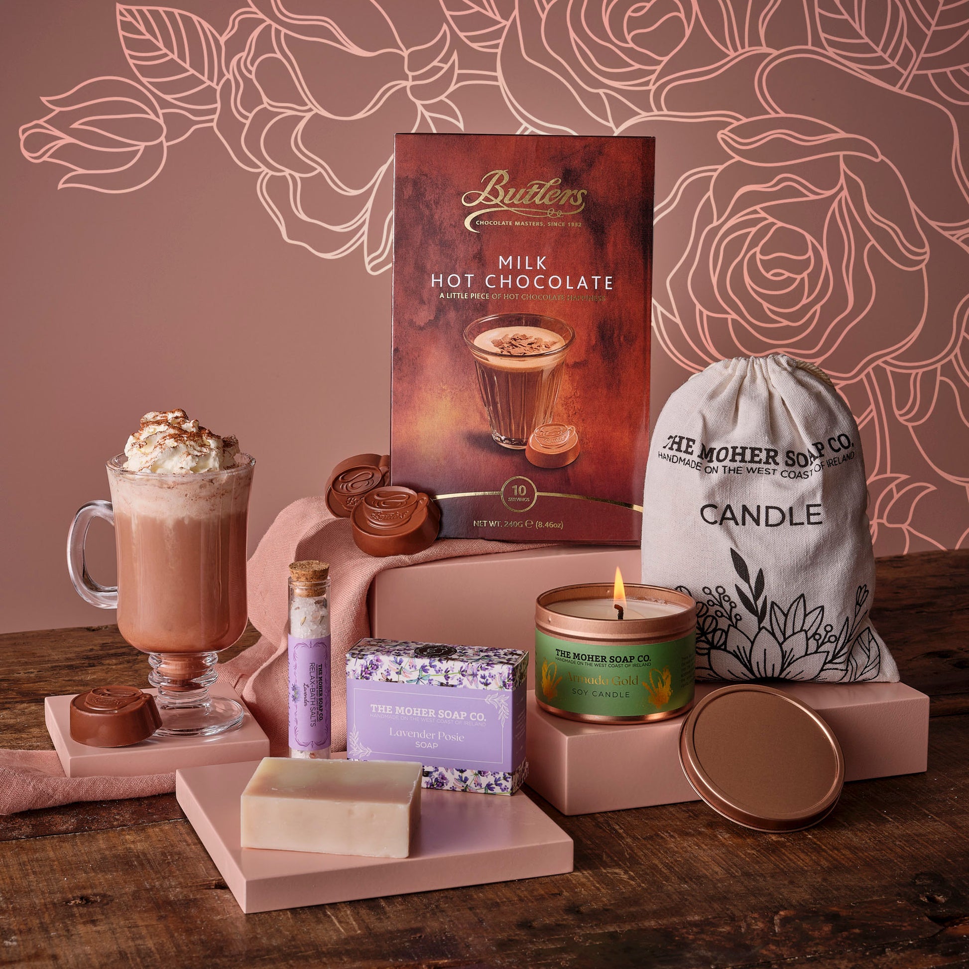 Time to Relax for Mum Hamper with a milk hot chocolate box, chocolate discs, and pampering items on a pink backdrop.