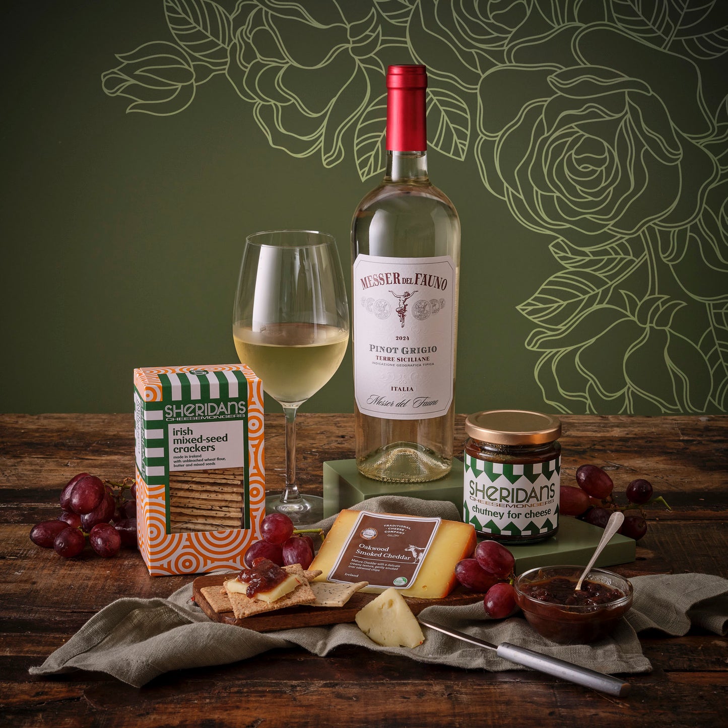 Mother’s Day White Wine and Treats Hamper featuring a Pinot Grigio bottle, wine glass, crackers, cheese and chutney with grapes.