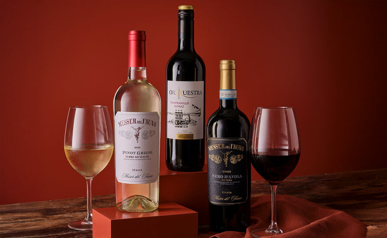 Bottles of red  and white wine with a glasses on a wooden surface with a warm, blurred background.